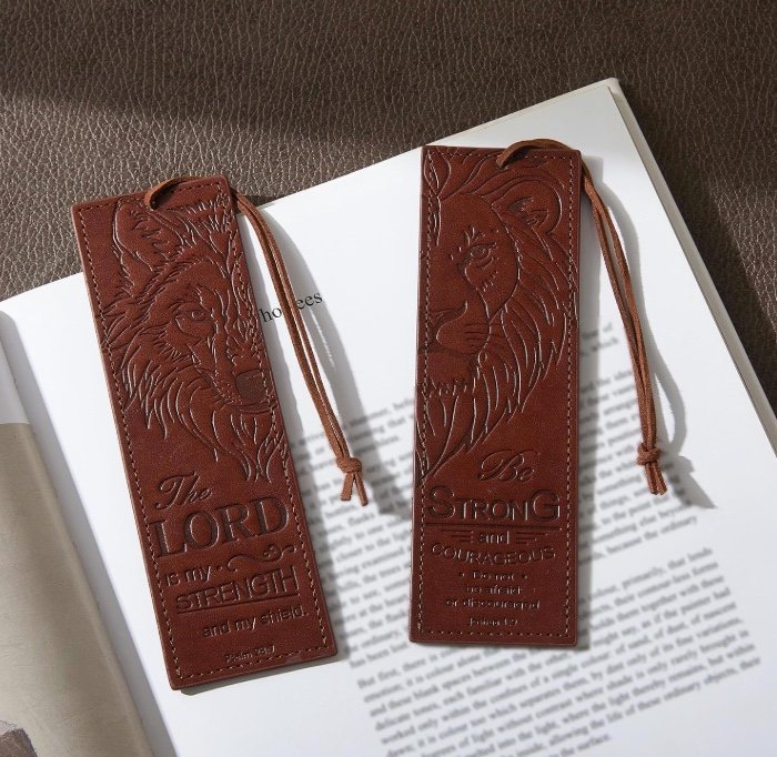 Two brown leather Bible bookmarks with embossed lion and wolf designs and Psalm 28:7 and Joshua 1:9 scripture.