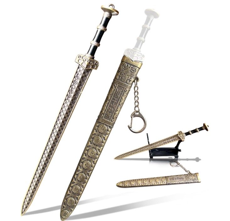 Miniature bronze Goujian-style sword letter opener with ornate scabbard, display stand, and keychain attachment on a white background.