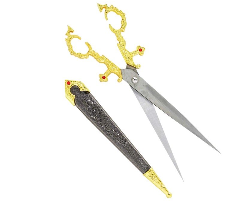 Ornate gold filigree medieval sword-style scissors with red gemstone hilts and a matching dark grey embossed scabbard.