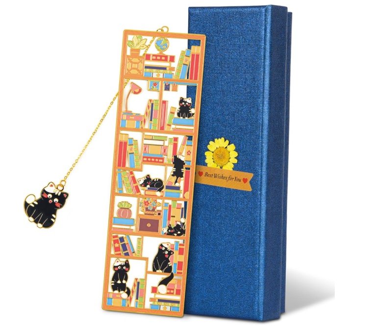 Gold metal bookshelf bookmark with black cats and a dangling cat charm, displayed beside its navy gift box.